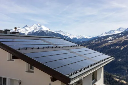 House roof with solar panels in the Swiss Alps. Depositphotos