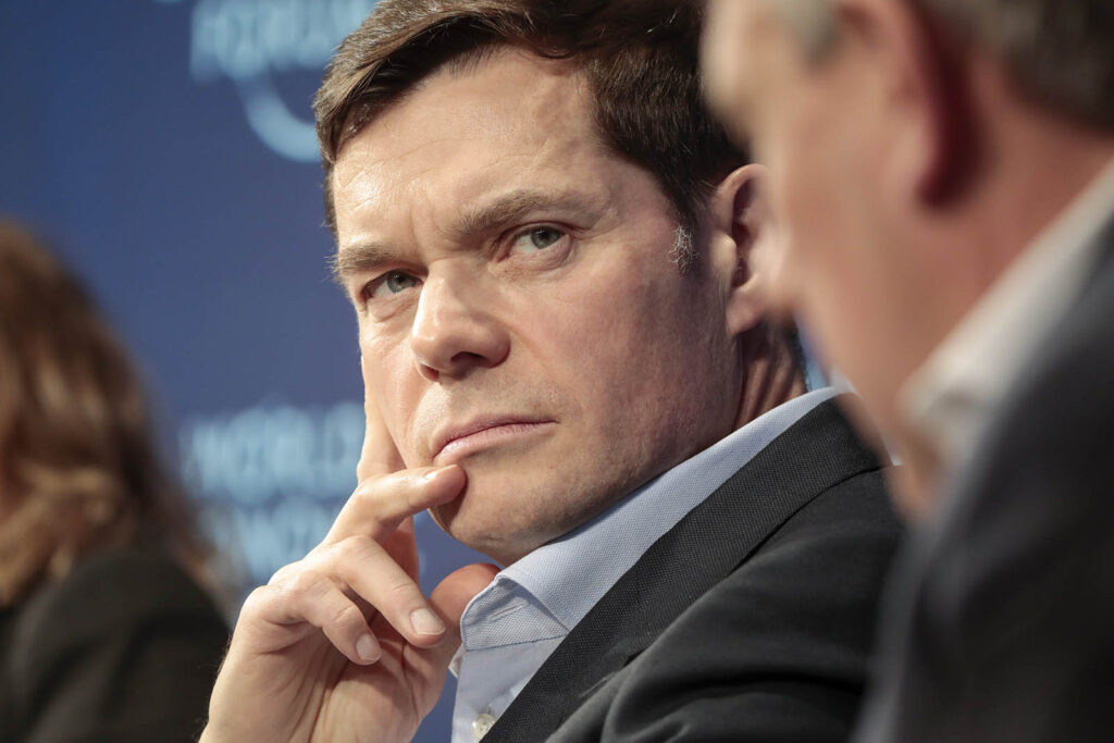 Day Two Of The World Economic Forum WEF 2018 - Petróleo y Energía Close-up of a man in a suit thoughtfully resting his chin during a panel discussion that is taking place off-camera, with a blue backdrop behind him