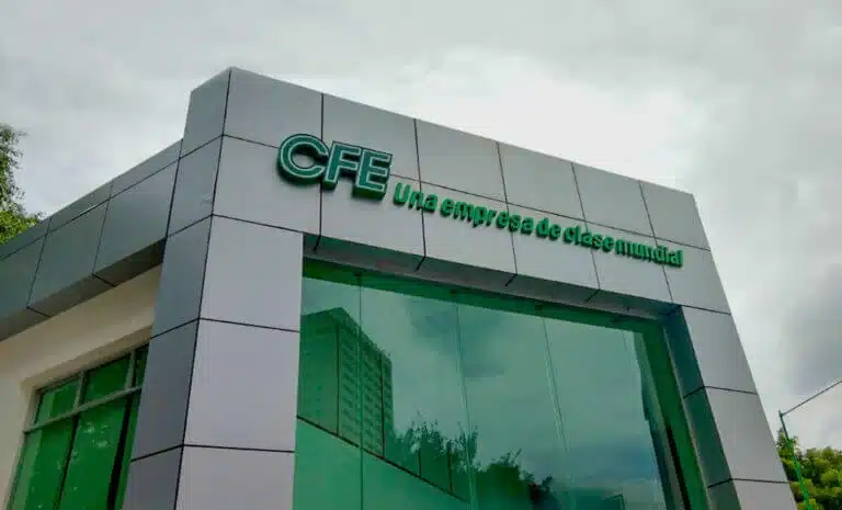 Commercial building facade with the sign 'CFE Una empresa de clase mundial' in teal letters against glass windows.