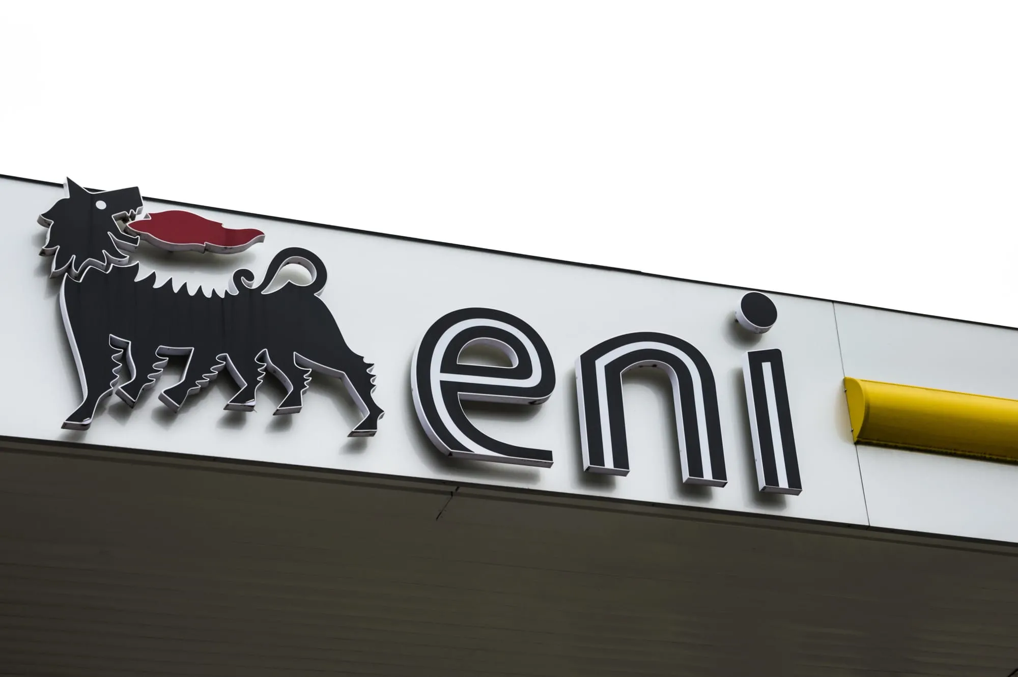 Close-up of a storefront sign showing a black dog silhouette with a red tongue on a white panel.