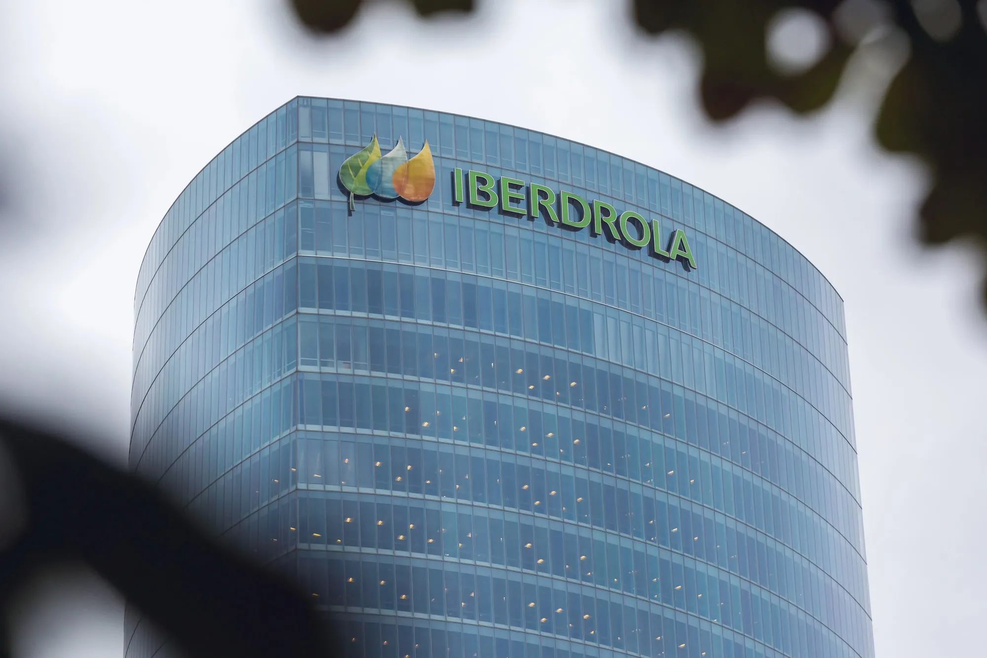 Modern glass office tower displaying the Iberdrola logo on the top corner.