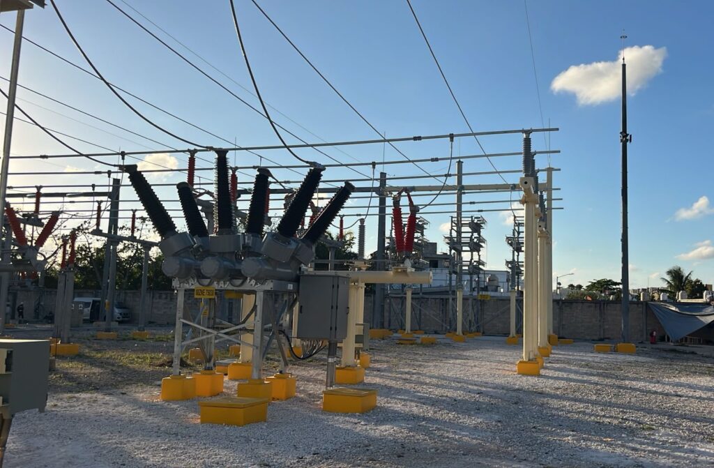 HGXgD6BbkAAflST - Petróleo y Energía High-voltage substation with many insulators and disconnectors, yellow safety barriers on gravel.