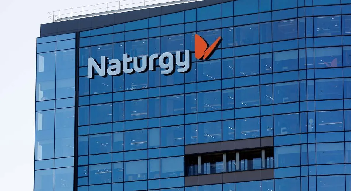 Modern glass office building with the Naturgy logo on the blue-tinted facade.