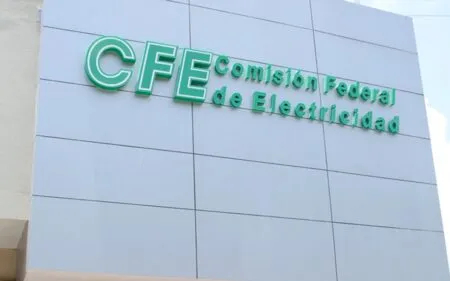 Green CFE sign reading 'Comisión Federal de Electricidad' on a blue-gray tiled building facade