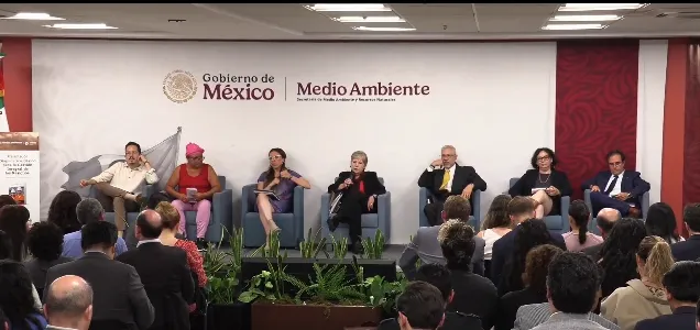 Panel of seven speakers seated on stage addressing a crowd at a Gobierno de México Medio Ambiente event in front of a banner backdrop.