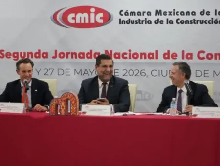 Panelists at a national construction conference behind a red table, CMIC banner visible in the background.