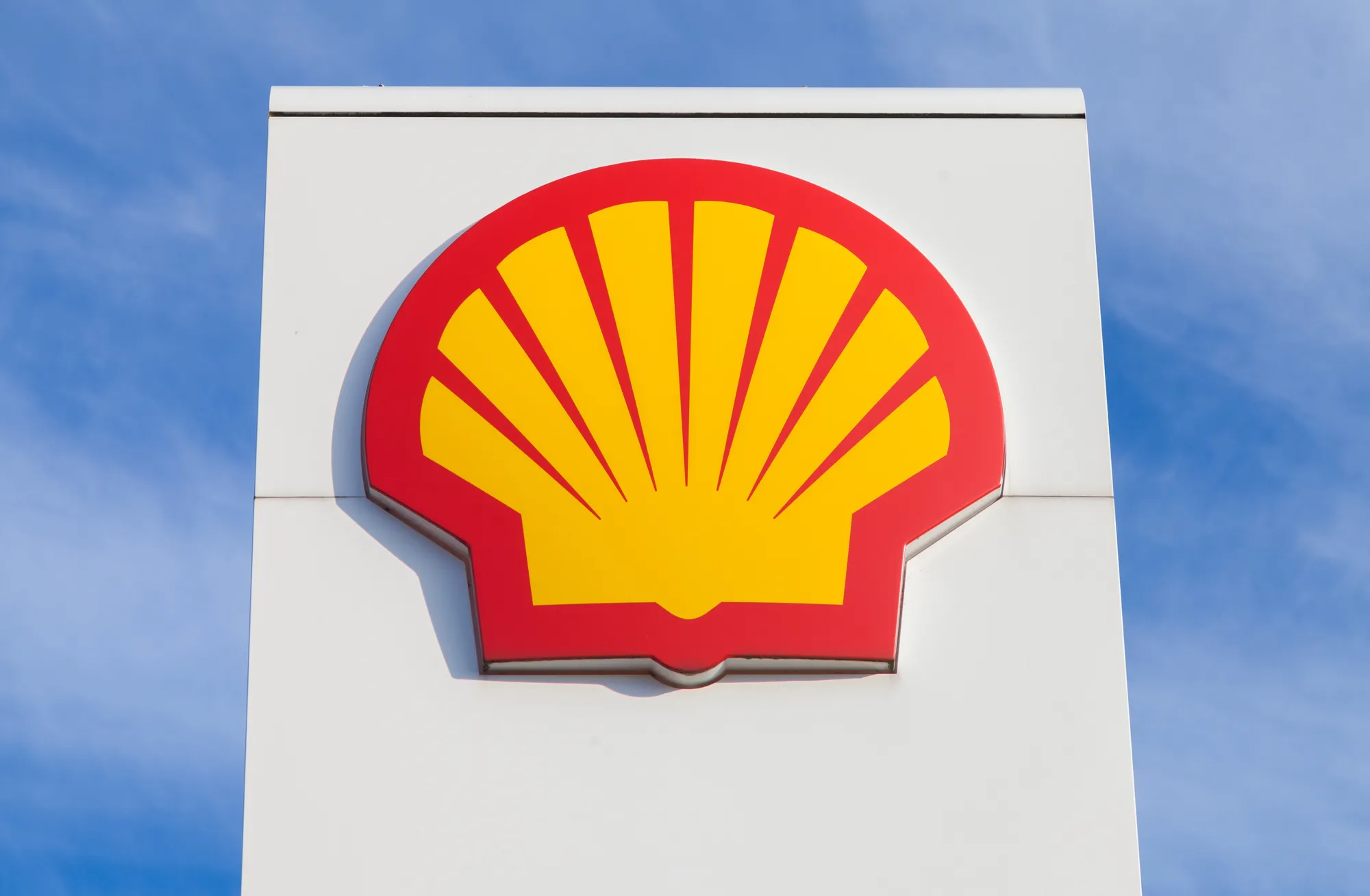 Shell logo on a white sign against a blue sky.
