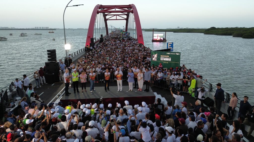 HHW4W5kbAAADsaG - Petróleo y Energía Large crowd fills a long pedestrian bridge over water for a staged event.