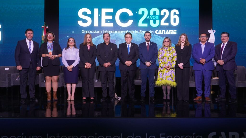 HI4KHD1WwAEqTwh - Petróleo y Energía Group of professionals in formal attire posing on stage at a conference with a large SIEC 2026 backdrop behind them.