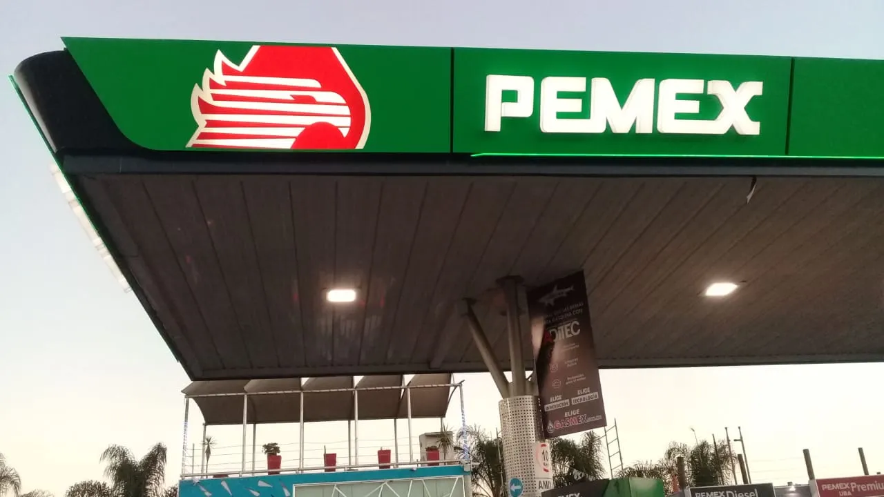 Pemex gas station canopy with green branding and logo on top, showing the word PEMEX and red emblem to the left.