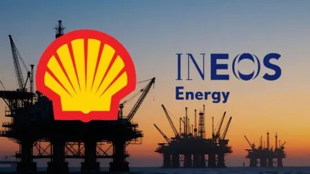 Silhouetted offshore oil rigs at sunset with a large Shell emblem and INEOS Energy branding overlay