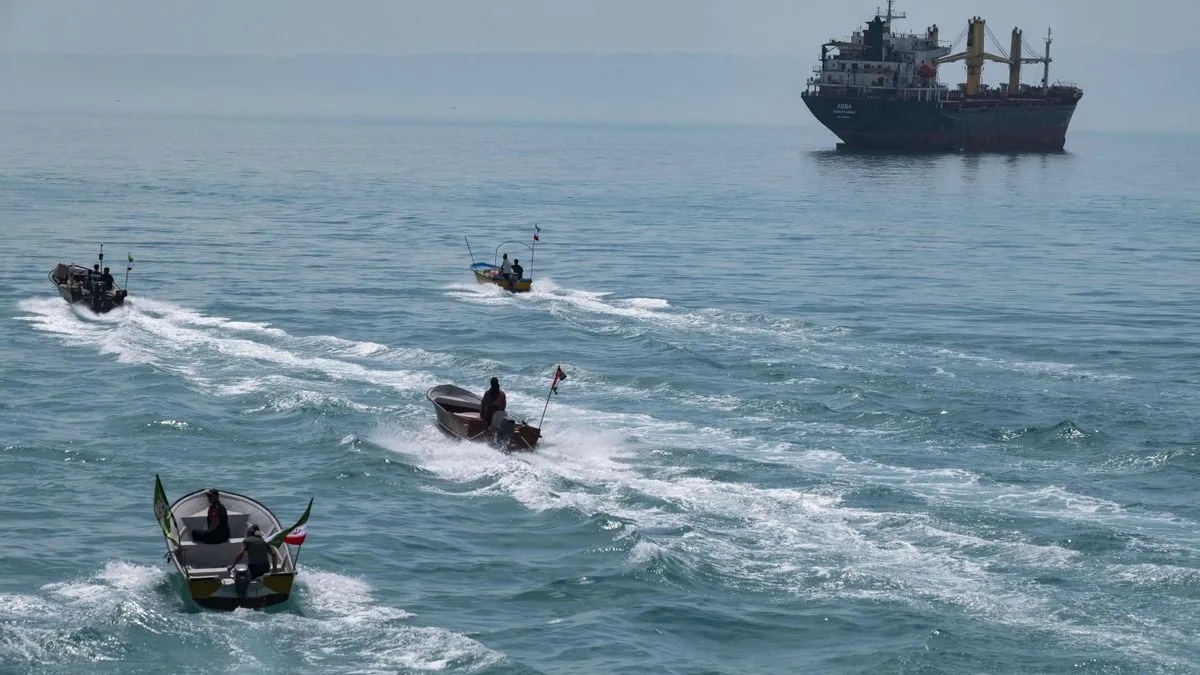 Several small boats speed across turquoise sea, leaving white wakes with a large cargo ship on the horizon.