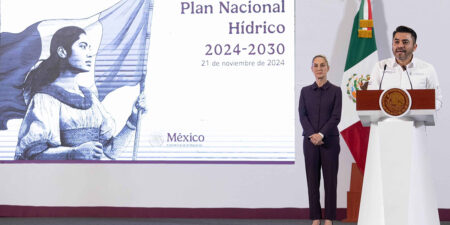 Speaker at a podium presenting the Plan Nacional Hídrico 2024-2030; a suited woman stands nearby with a Mexican flag in the background.