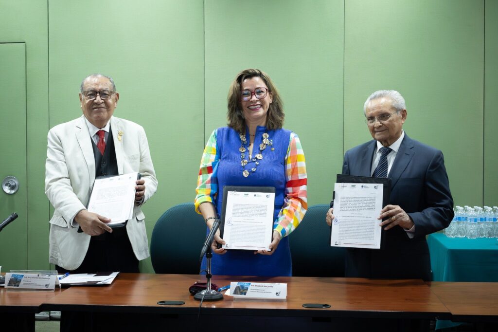 1781619967841 - Petróleo y Energía Three professionals pose with signed documents in a conference room; center woman in a blue vest smiles.
