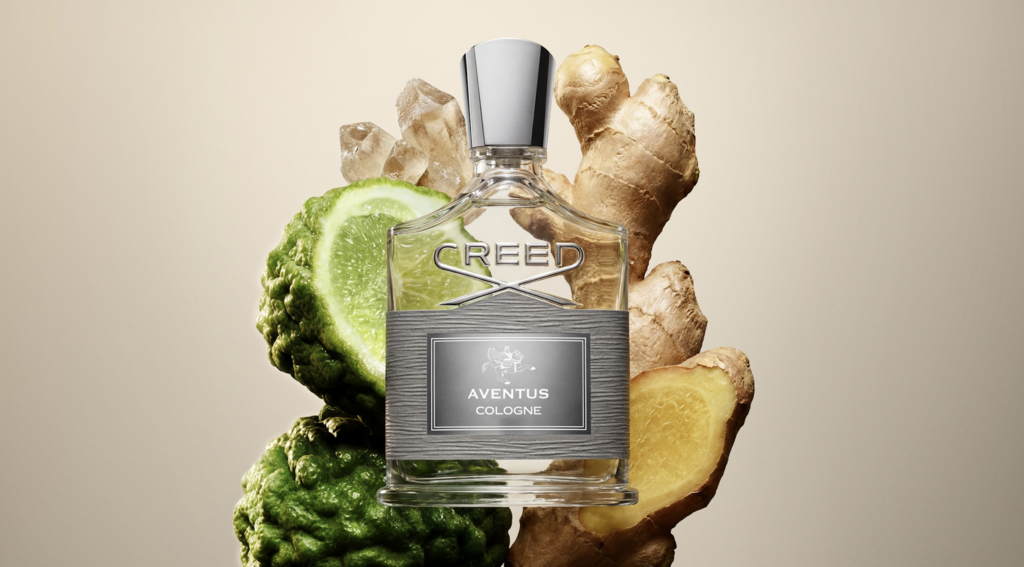 Aventus 5 - Petróleo y Energía Creed Aventus cologne bottle centered, surrounded by lime and ginger slices and roots.