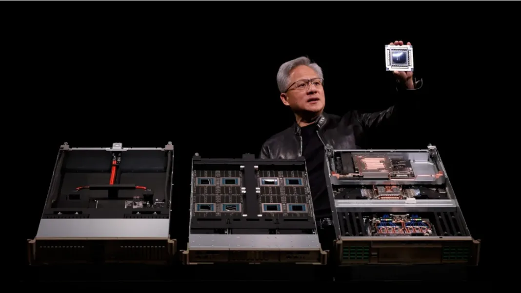 A man in a black jacket stands behind three open computer server chassis, holding up a CPU chip for display against a black background.