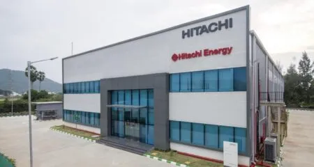 Front view of a modern Hitachi Energy office building with blue-tinted windows and the Hitachi sign on the facade