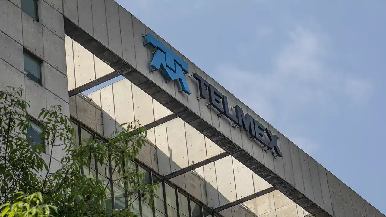 Exterior view of a modern concrete building with a Telmex sign and blue logo on the top edge