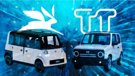 Two white vans facing each other against a blue abstract background with a large white bird silhouette and bold white TT lettering above them.
