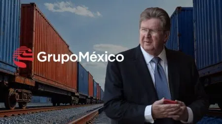 Grupo México logo over a backdrop of colorful freight containers with a man in a suit standing beside the logo in a rail yard background.