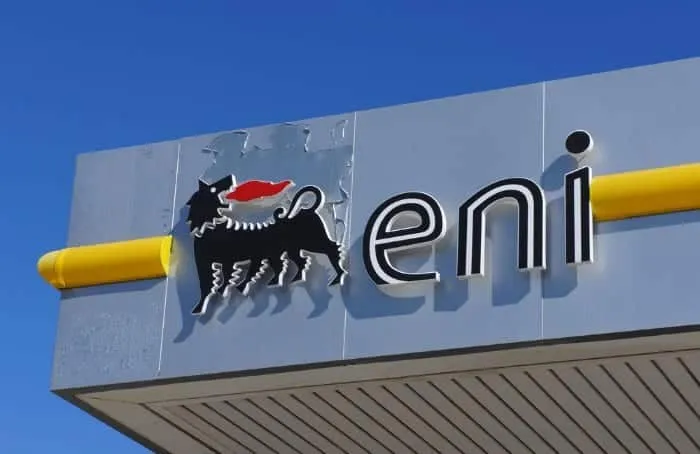 ENI signage with the black six-legged dog and red flame logo beside bold 'eni' letters against a blue sky.