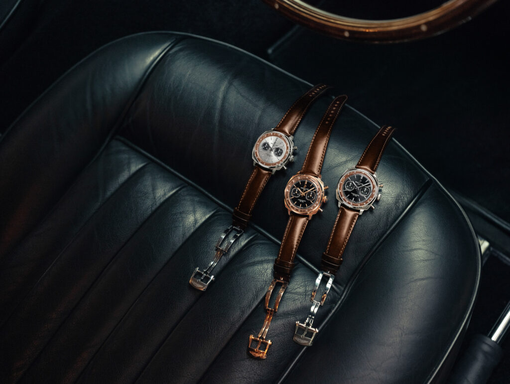 02_Breitling-Top-Time-B01-Chronograph-41-Tribute-to-Aston-Martin-DB5_RGB - Petróleo y Energía Several luxury watches with brown leather bands laid out on a dark leather surface, showing metal cases and dials close-up on a chair cushion.