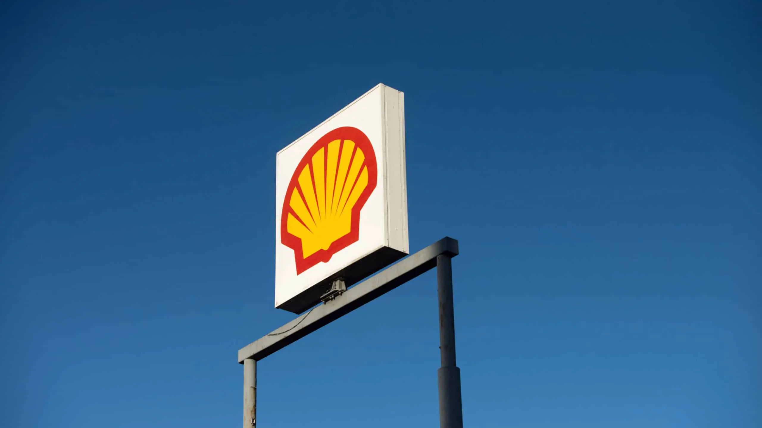 Shell logo sign mounted on a metal frame against a clear blue sky.