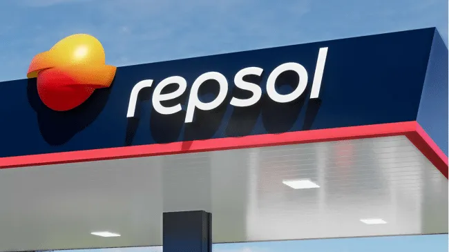 Repsol gas station sign with its yellow-orange logo on a blue background above the canopy edge.