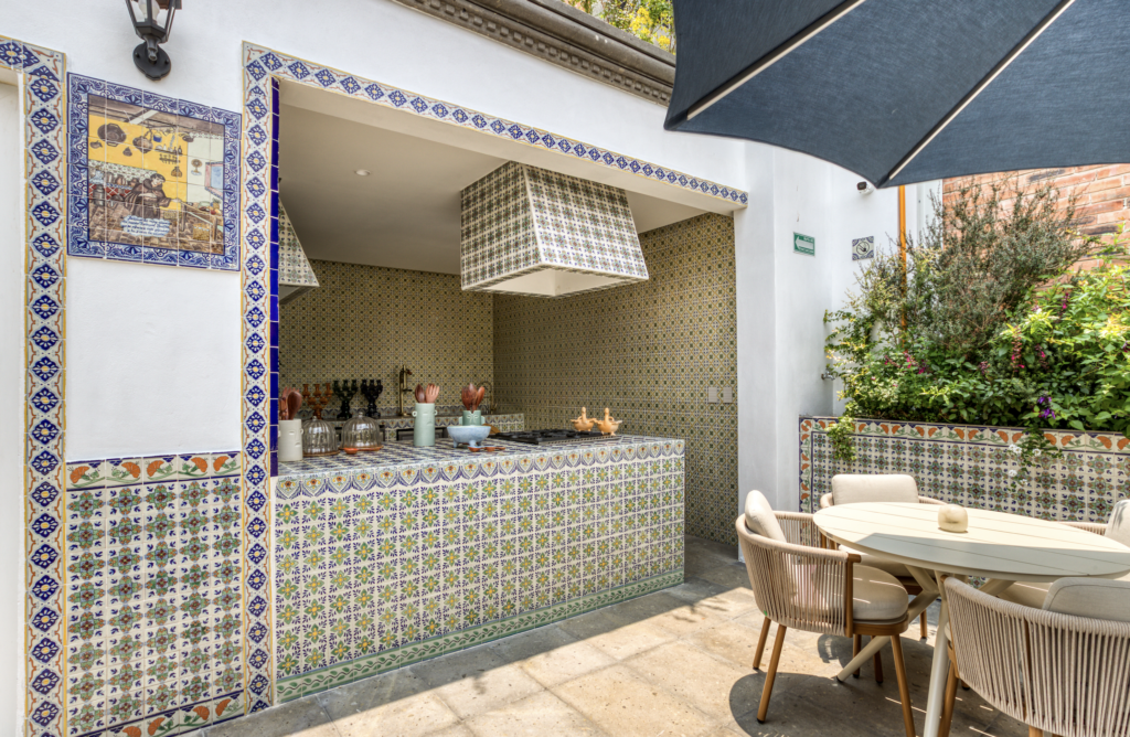 CASA TALAVERA 3 - Petróleo y Energía Outdoor cafe-style bar with vibrant azulejo tilework, counter, and wicker chairs beneath a large umbrella on a sunny patio