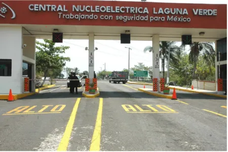 Toll plaza at Laguna Verde Nuclear Power Plant entrance with lanes marked ALTO and workers near the gate.