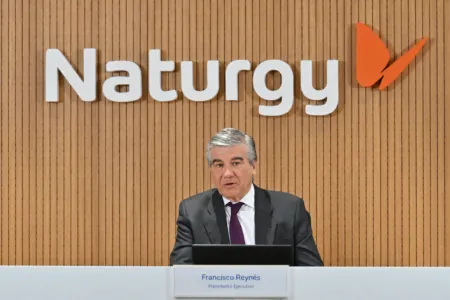 Francisco Reynés, executive president, speaking at a Naturgy press conference behind a wood-paneled wall with the Naturgy logo