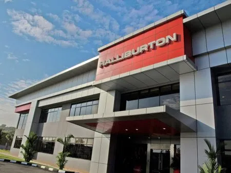 Modern office building with a red Halliburton sign on the facade against a blue sky Societal image?