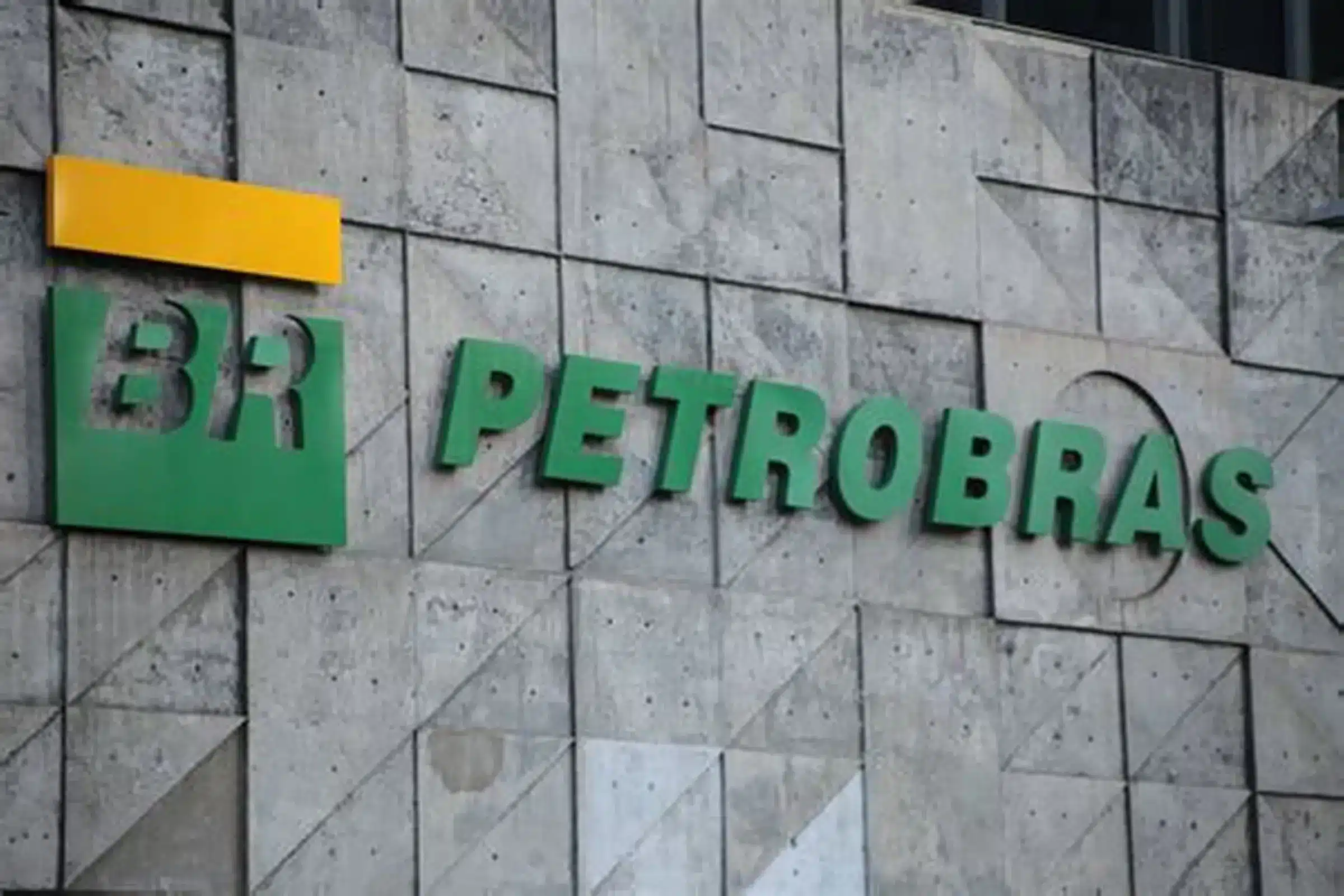 Petrobras logo on a gray stone wall, with green letters and an orange rectangular shape above the sign.