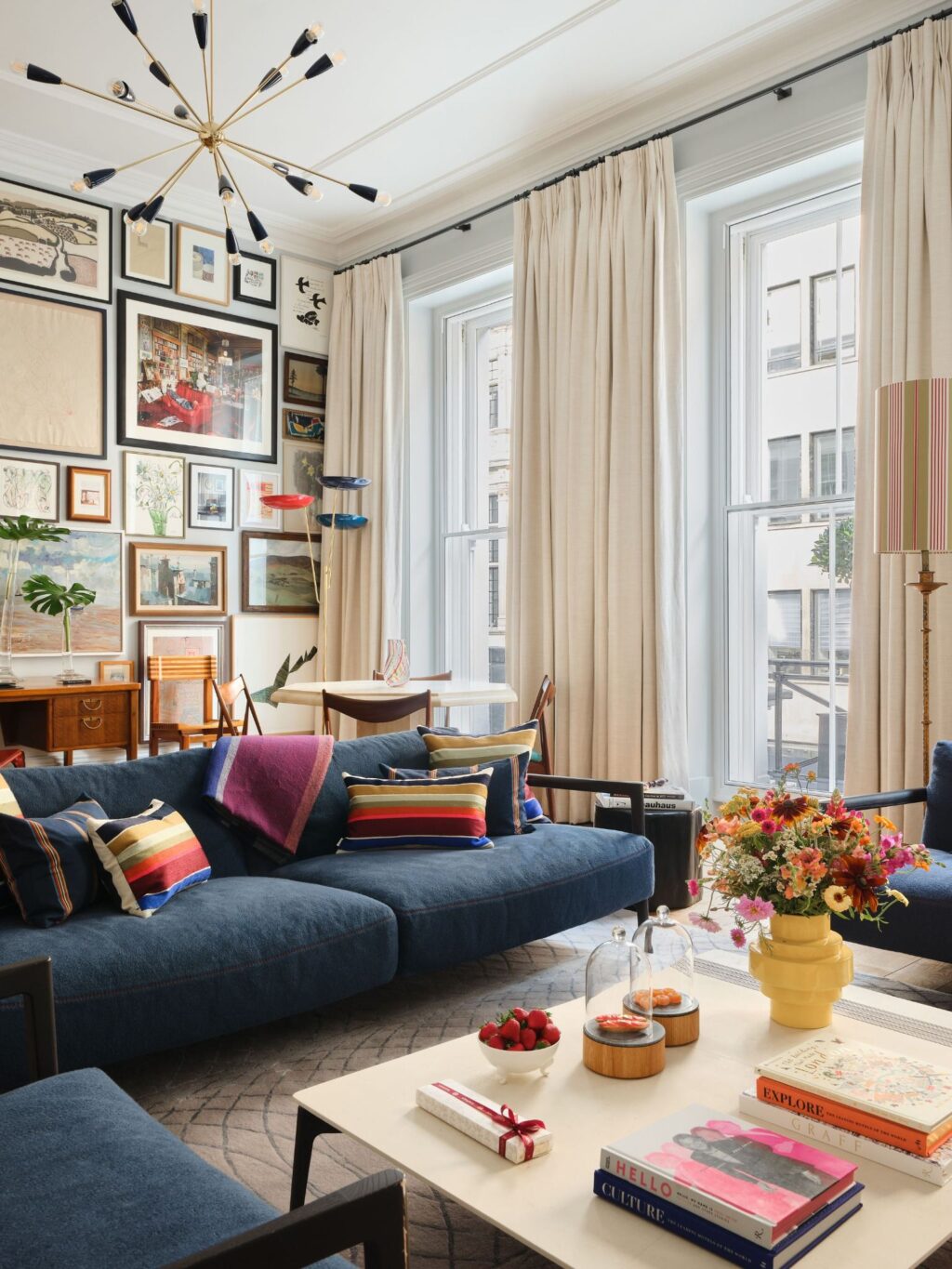 RFF4A0~1 - Petróleo y Energía Cozy living room with a deep blue sectional, striped cushions, and a wall of framed art.