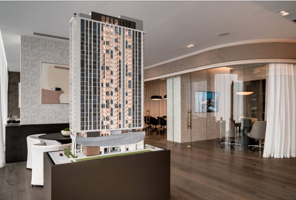 ROC4 - Petróleo y Energía Scale model of a high-rise residential tower on a display table in a modern showroom.