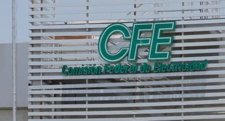 Teal CFE sign on a slatted gray facade reading 'Comisión Federal de Electricidad'.