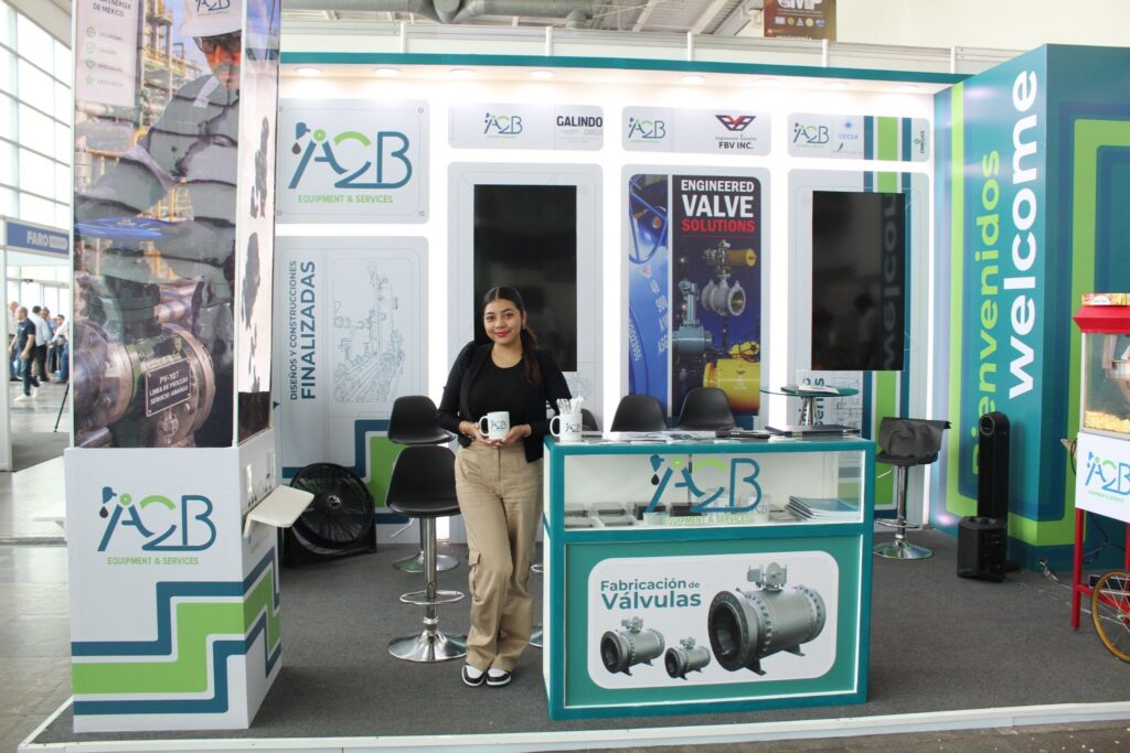 image - Petróleo y Energía Woman standing at an exhibition booth labeled 'ACB Equipment & Services' with industrial graphics and valves on display.