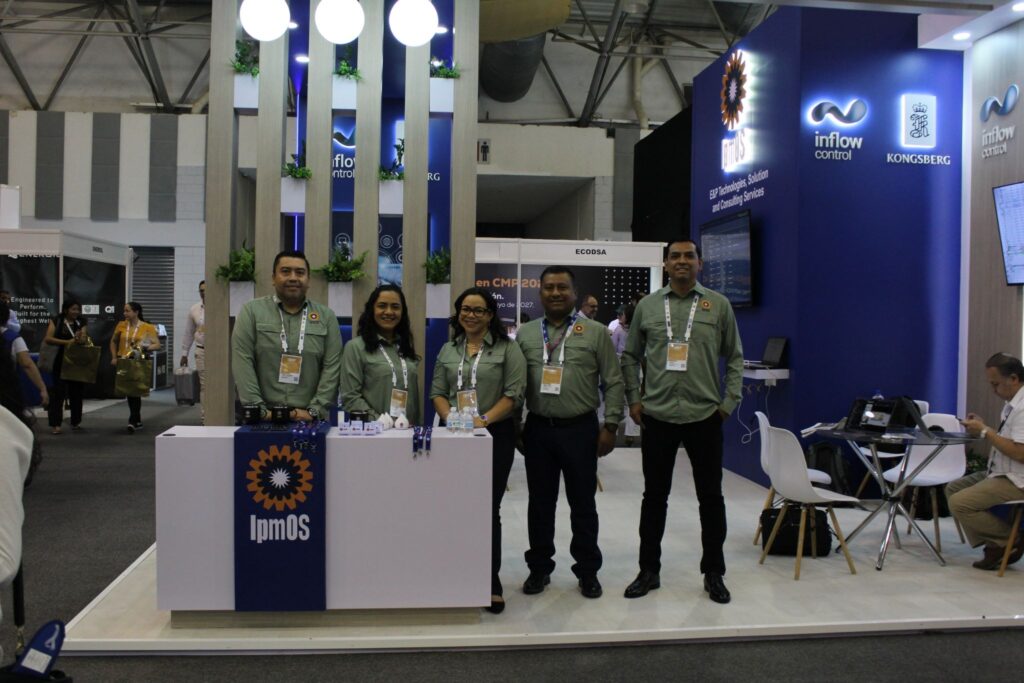 image - Petróleo y Energía Team of five exhibitors in green shirts standing behind a white booth with an orange gear logo and 'ImPOS' at a blue expo display center.