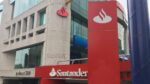 Santander bank storefront with large red panels and white bank logo on a modern building facade