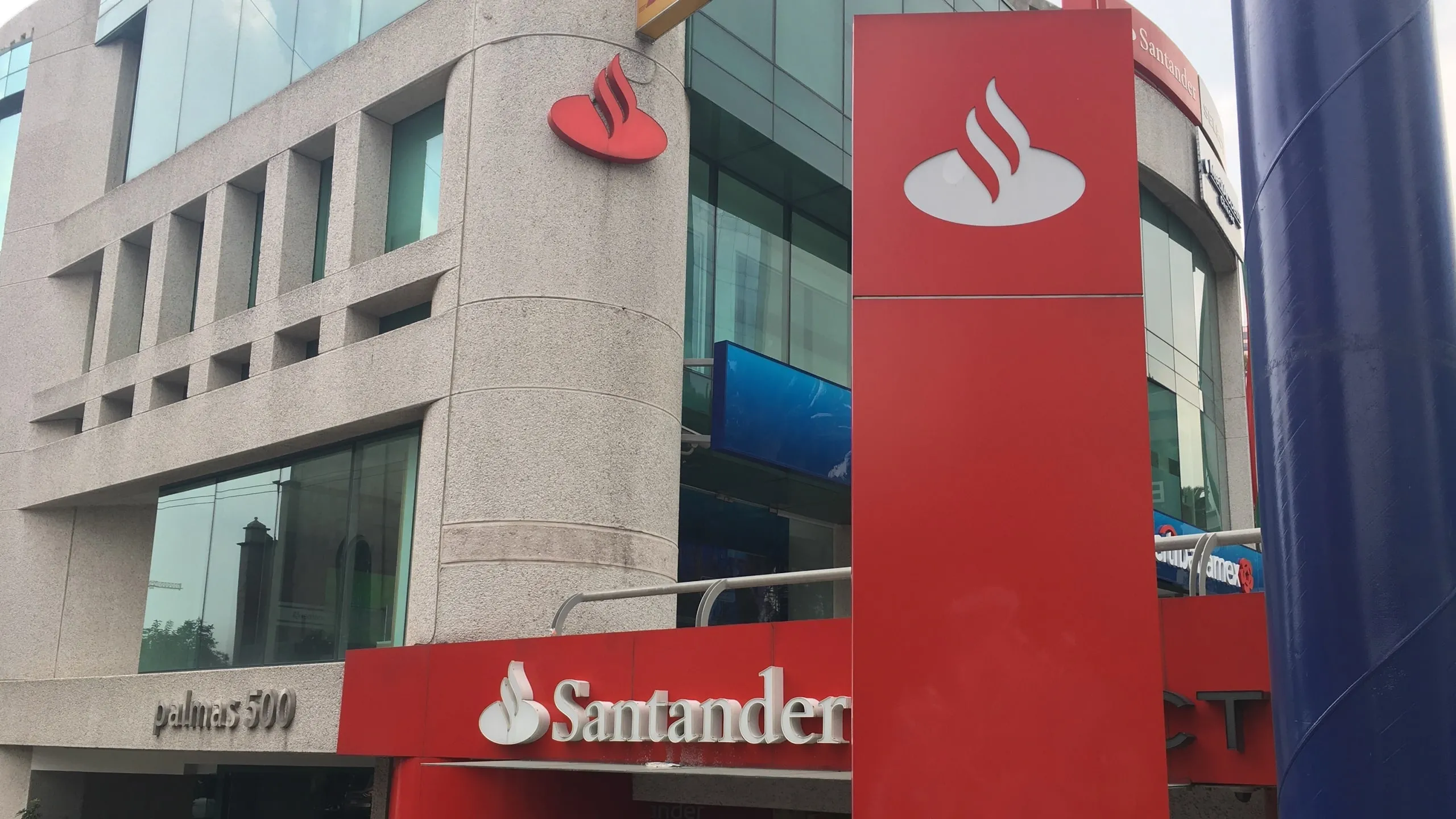 Santander bank storefront with large red panels and white bank logo on a modern building facade