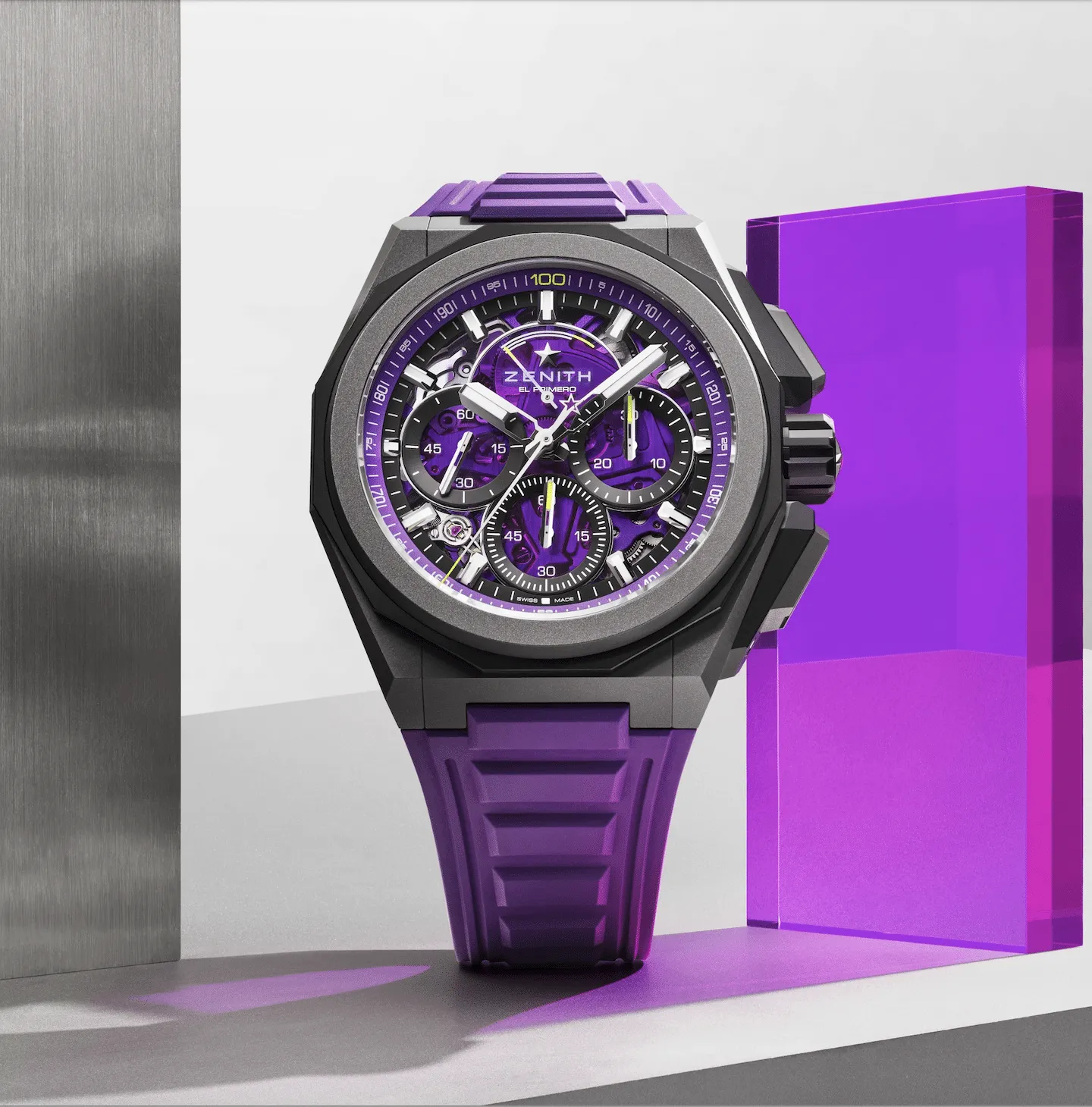 Skeleton-dial Zenith El Primero chronograph watch with purple accents and purple strap between metallic panels.