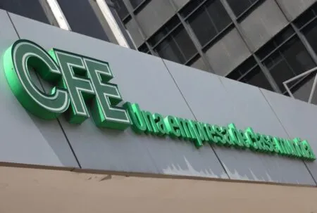 Green CFE logo sign mounted on a gray building facade, indicating the company branding.