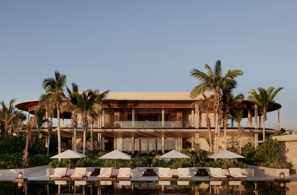 Amnavari 3 - Petróleo y Energía Resort-style building with palm trees, poolside lounge chairs, and white umbrellas along a reflective pool under a clear blue sky.