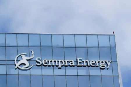 Modern glass office building with blue-tinted panels and the partial logo 'Sempra Energy' along the lower edge.