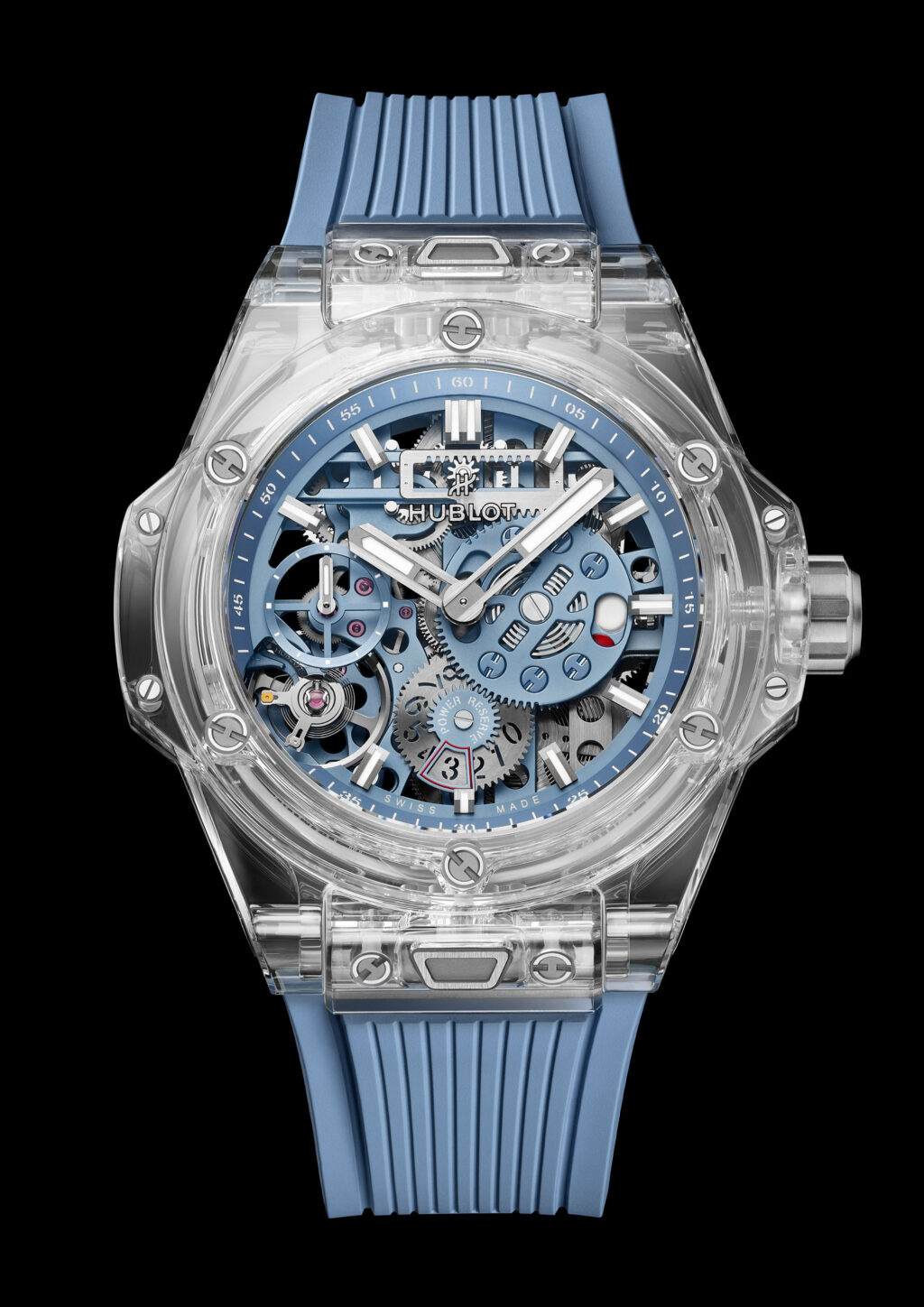 Hublot_Big Bang Sapphire Sky Blue 6 1 - Petróleo y Energía Skeleton watch with transparent case and blue gears; blue strap and visible mechanical movement showing gears and screws.