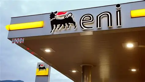 ENI gas station canopy with the black six‑legged dog logo and the letters 'eni' under a blue sky.