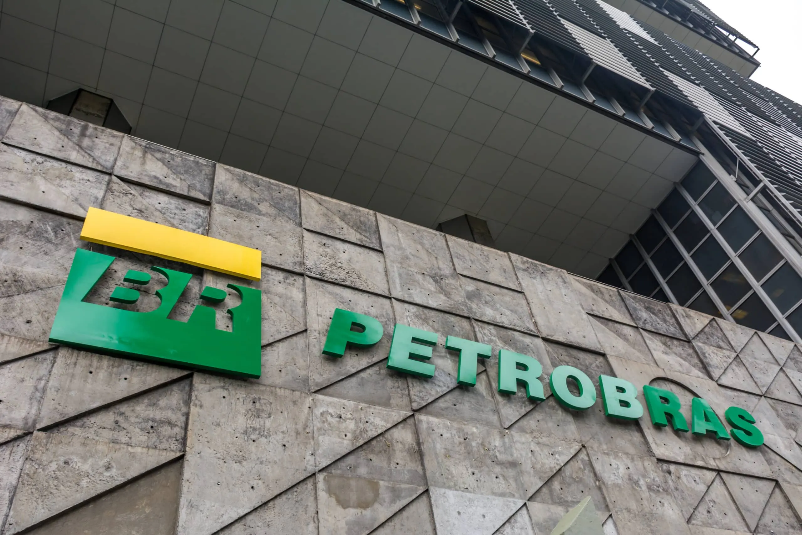 Exterior view of a modern office building facade with the Petrobras sign in green letters and a yellow accent above.
