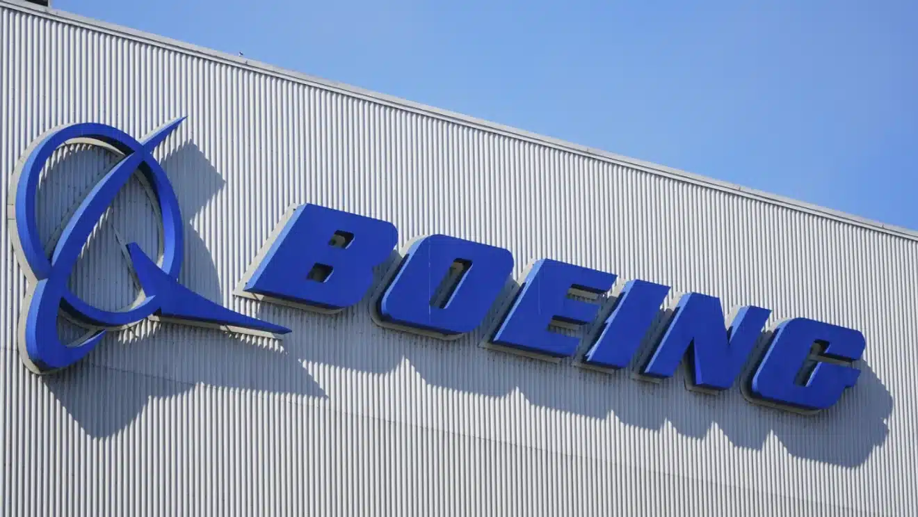 Blue Boeing logo and sign mounted on a corrugated gray building wall.