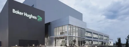 Exterior view of a modern Baker Hughes office building with the company logo on a dark tower site signage visible.