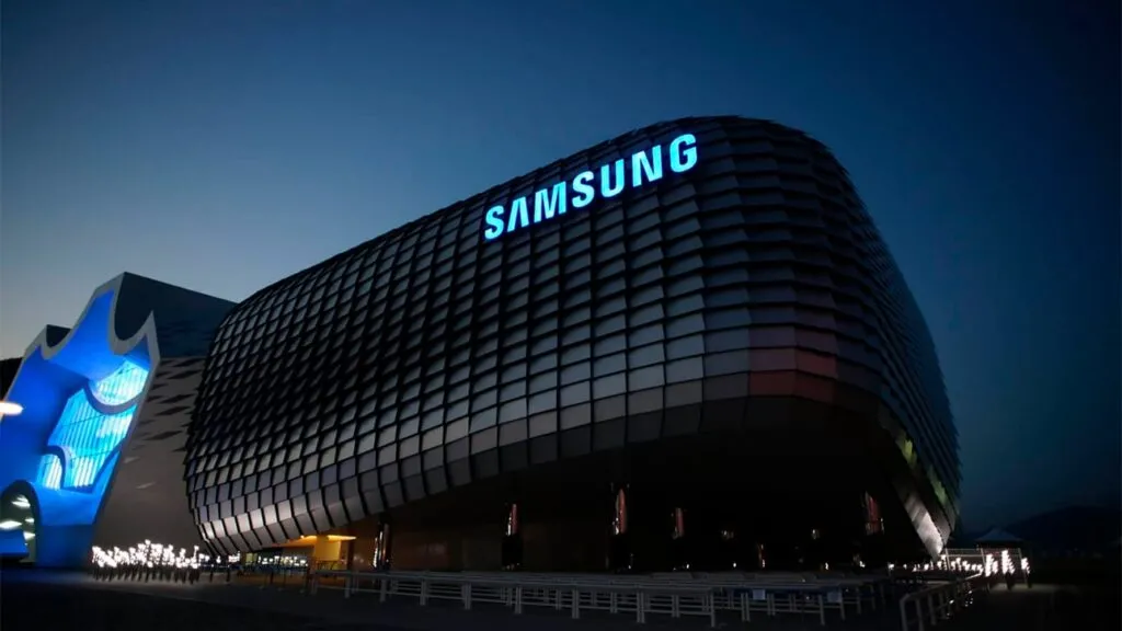 Samsung building at night with a curved, grid-patterned facade and a blue Samsung sign.